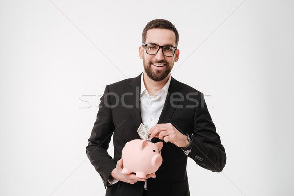 Cheerful businessman holding moneybox. Stock photo © deandrobot