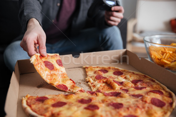 Junger Mann spielen Spiele Joystick Essen Bild Stock foto © deandrobot