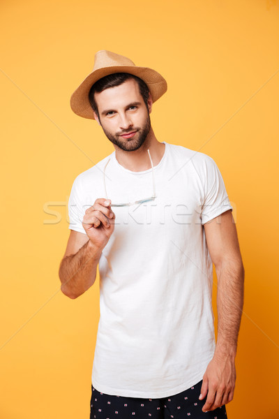 Serious young man standing isolated over yellow background Stock photo © deandrobot