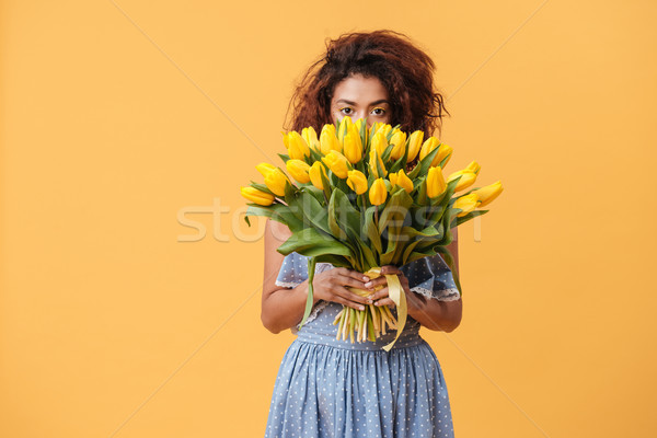 Pretty African woman hiding behind bouquet of flowers Stock photo © deandrobot