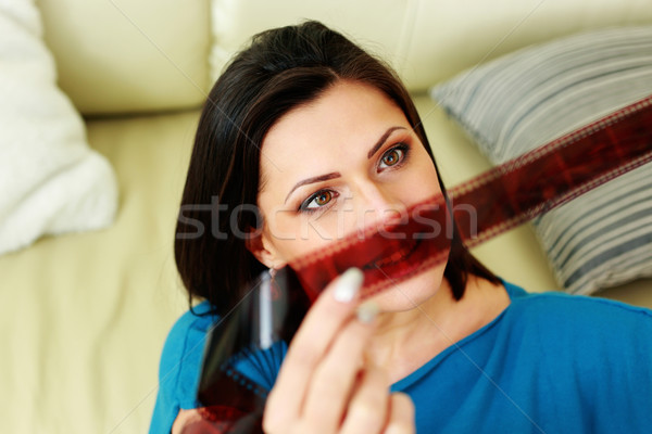 Middle-aged happy woman looking on a photo film at home Stock photo © deandrobot