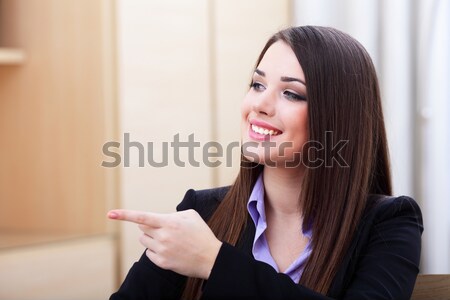 Young happy businesswoman holding smartphone in office Stock photo © deandrobot