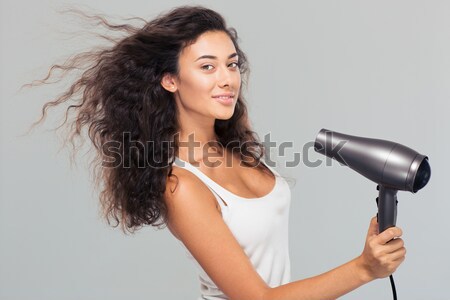 Pretty woman holding hairdryer  Stock photo © deandrobot
