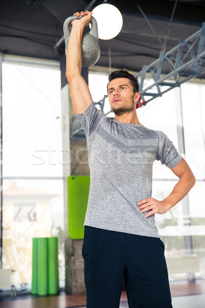 Man doing exercises with kettle ball at gym Stock photo © deandrobot