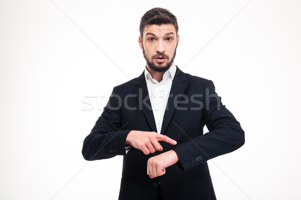 Handsome astonished young business man with beard pointing on watch Stock photo © deandrobot