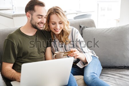 Gelukkig paar met behulp van laptop computer sofa portret Stockfoto © deandrobot