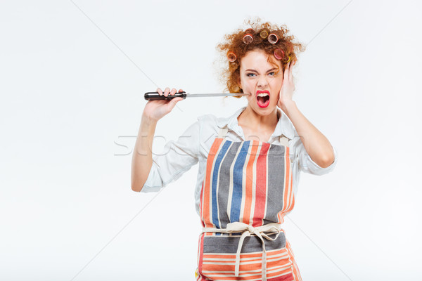 Curly housewife in striped apron holding and playing with knife  Stock photo © deandrobot