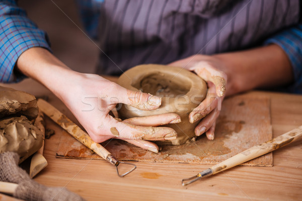 Clay pot making by hands of woman in pottery workshop Stock photo © deandrobot