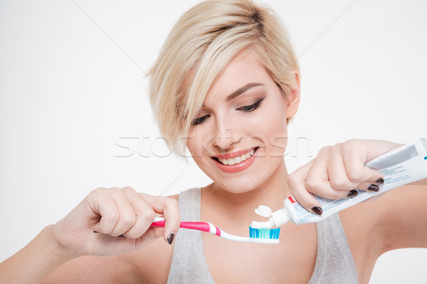 Femme brosse à dents dentifrice femme souriante isolé [[stock_photo]] © deandrobot