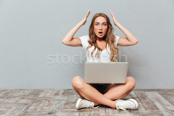 Kobieta posiedzenia skrzyżowanymi nogami laptop Zdjęcia stock © deandrobot