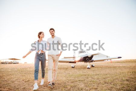 Couple walking together across the field at sunset Stock photo © deandrobot