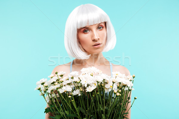 Pretty young woman in blonde wig holding bunch of flowers Stock photo © deandrobot