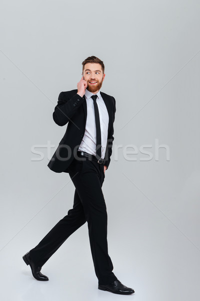 Full length business man moves and talking at phone Stock photo © deandrobot