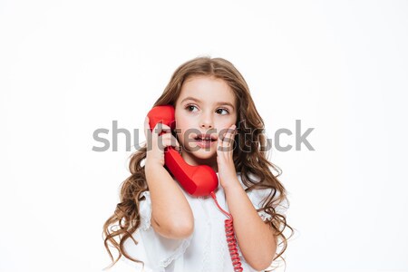 Stock photo: Surprised charming little girl calling and talking on red telephone