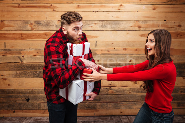 Happy joyful couple celebrating new year with heap of presents Stock photo © deandrobot