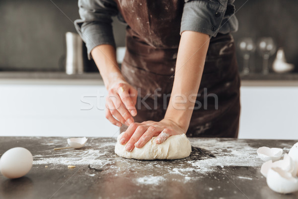 Cropped image of young woman cooking the dough. Stock photo © deandrobot