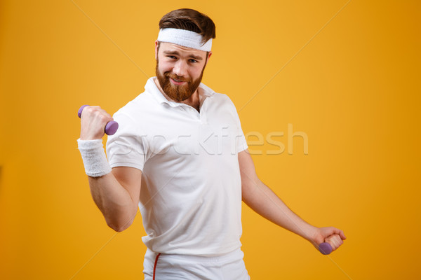 Funny sportsman doing exercise with lightweight dumbbells Stock photo © deandrobot