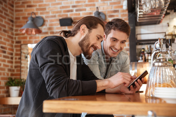 Stockfoto: Zijaanzicht · vrienden · bar · naar · telefoon · permanente