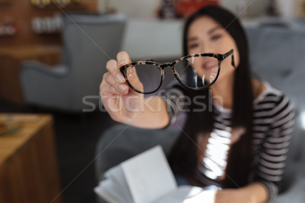Asian woman showing eyeglasses at camera Stock photo © deandrobot
