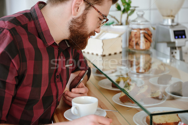 Cropped image of a handsome man choosing sweet pastry Stock photo © deandrobot