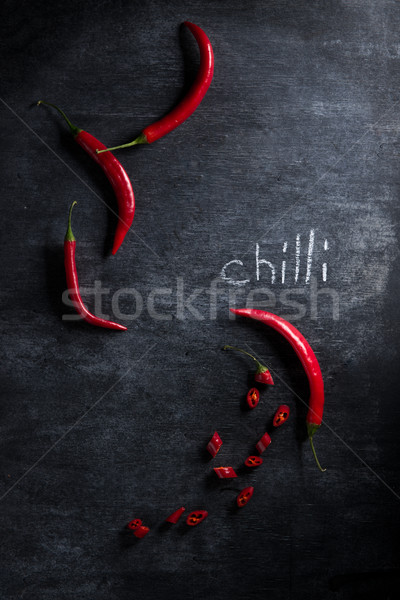 Picture of cut chilli pepper over dark background. Stock photo © deandrobot