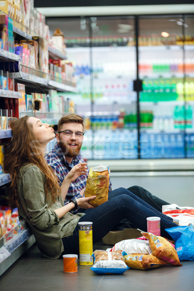 Pár ül áruház padló eszik harapnivalók Stock fotó © deandrobot