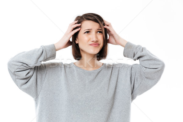 Young confused woman keeping her hands on head Stock photo © deandrobot
