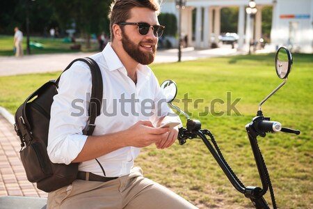 Vue de côté calme barbu homme lunettes de soleil sac à dos Photo stock © deandrobot