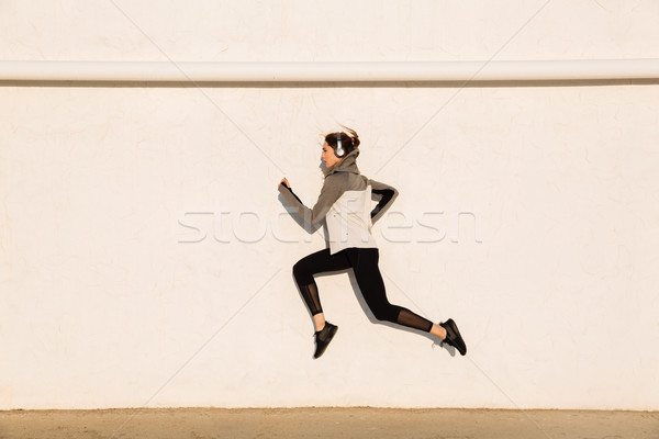 Full length photo of young fitness woman in sport wear jumping n Stock photo © deandrobot