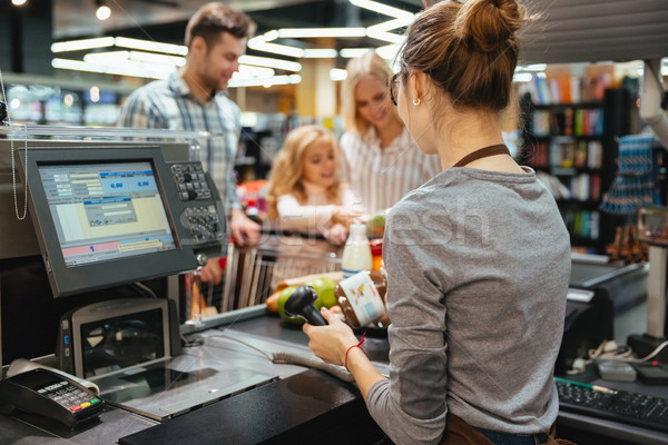 Beautiful family standing at the cash counter Stock photo © deandrobot