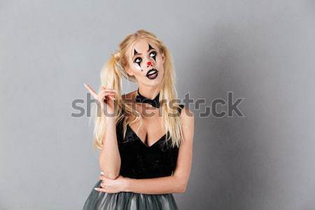 Young woman holding fake moustache showing peace gesture. Stock photo © deandrobot