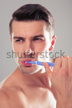 Brunette happy guy 30s being undressed at bathroom with shaving  Stock photo © deandrobot