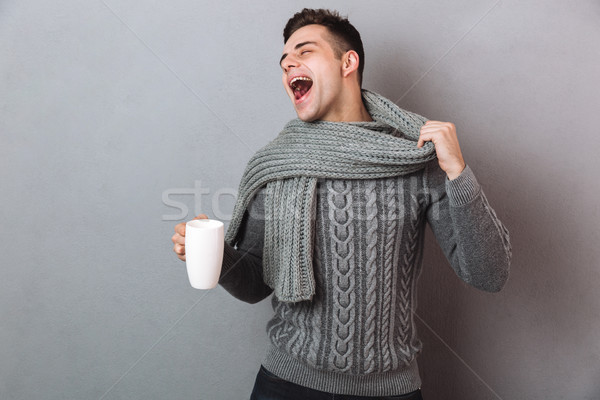 Happy Sick Man in sweater holding his scraf and cup Stock photo © deandrobot
