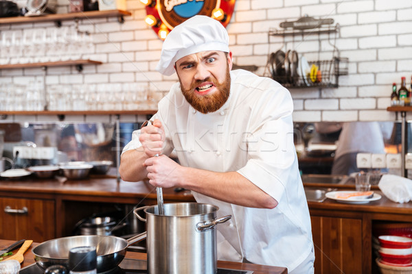 Funny bearded chef cook staning and cooking soup Stock photo © deandrobot
