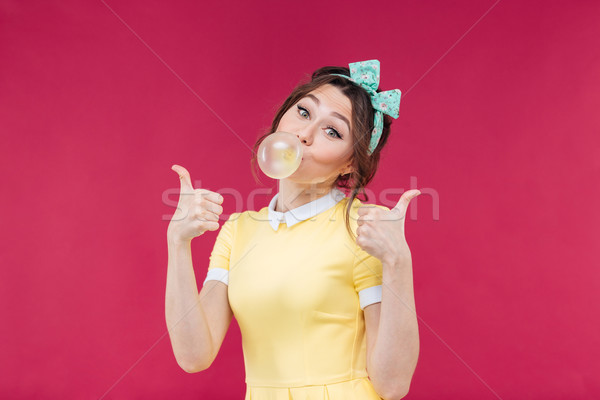 Happy lovely young woman with pink bubble of chewing gum Stock photo © deandrobot