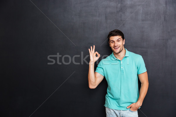 Mosolyog fiatalember áll mutat ok felirat Stock fotó © deandrobot