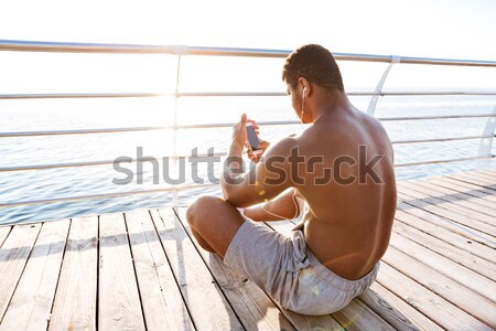 Afro american sports man resting after workout and listen music Stock photo © deandrobot