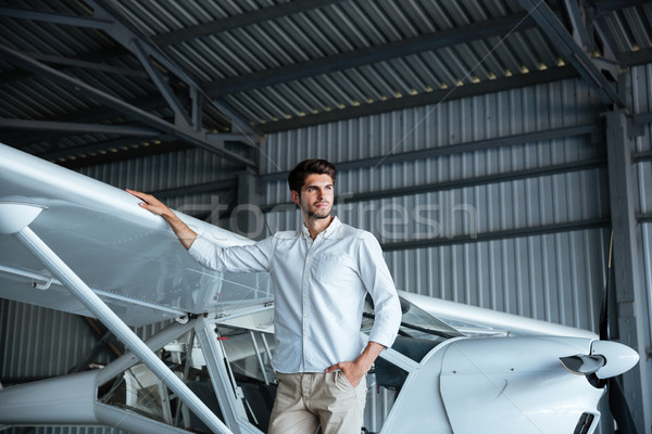 Handsome young man standing near smal airplane Stock photo © deandrobot