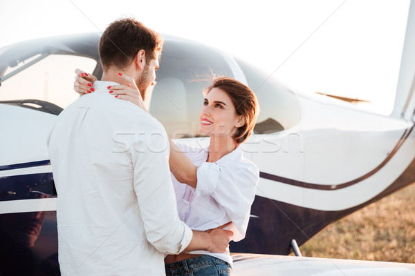Young beautiful couple together with airplane on background Stock photo © deandrobot