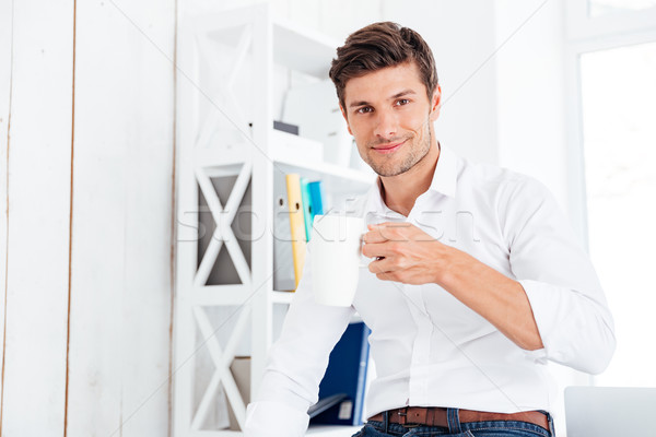 Sonriendo jóvenes empresario potable taza té Foto stock © deandrobot