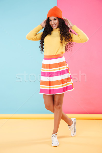 Full length of cheerful african young woman standing and smiling Stock photo © deandrobot