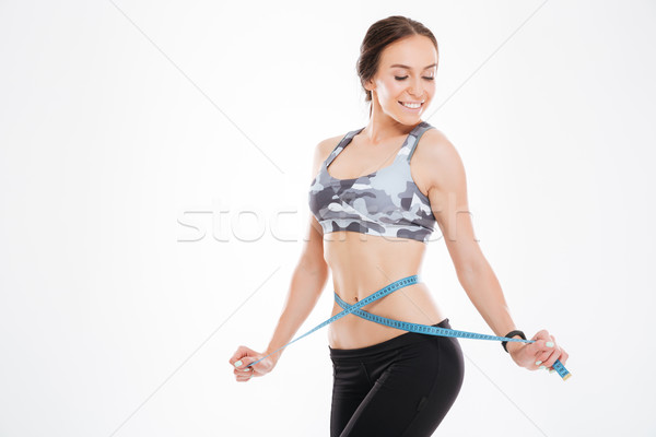 Smiling woman with measuring tape Stock photo © deandrobot