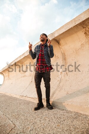 Cheerful man with arms spread opened standing at the beach Stock photo © deandrobot