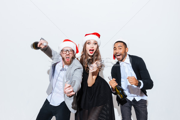 Funny friends with bottle of champagne and glasses having fun Stock photo © deandrobot