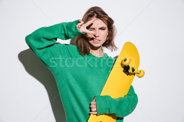 Stock photo: Gorgeous skater lady holding skateboard.