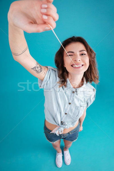 Young funny teen girl stretching and playing with buble gum Stock photo © deandrobot