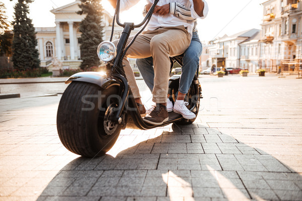 Cropped image of african couple rides on modern motorbike Stock photo © deandrobot