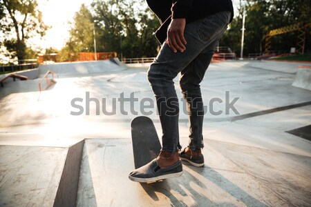 Cropped image of a young male teenager riding a skateboard Stock photo © deandrobot