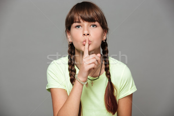 Pretty girl jumping isolated grey background showing silence gesture. Stock photo © deandrobot