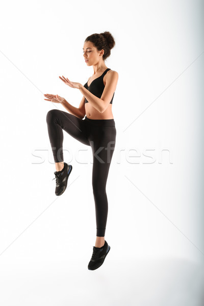 Full length image of Concentrated fitness woman jumping in studio Stock photo © deandrobot